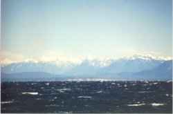 Die Coast Mountains und Georgia Strait von der Seal Bay aus gesehen.